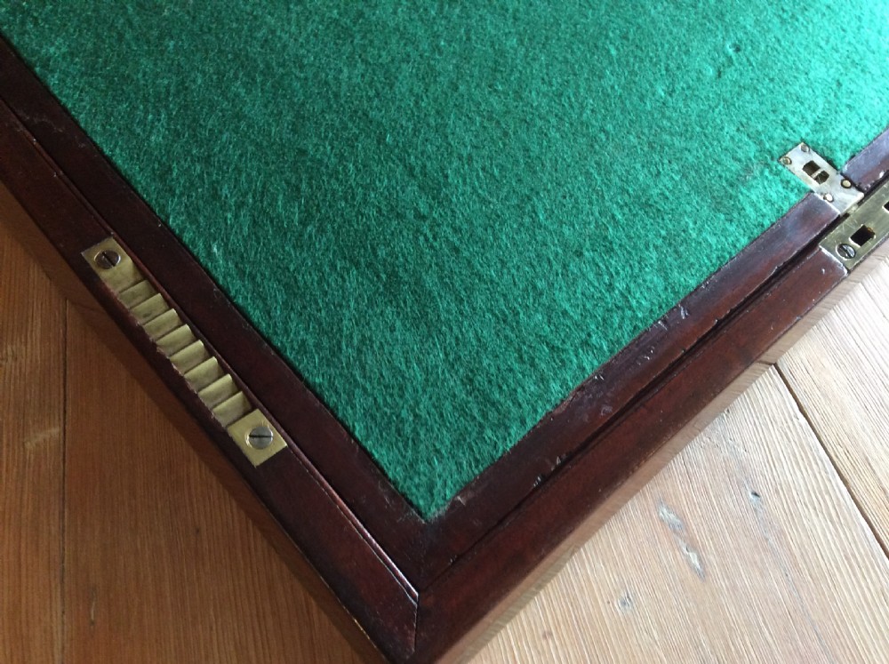 A rectangular mahogany campaign writing slope with flush brass corner brackets, brass straps, and a decorative brass keyhole escutcheon. View X