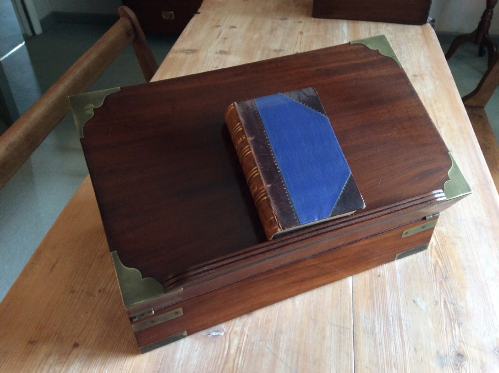 A rectangular mahogany campaign writing slope with flush brass corner brackets, brass straps, and a decorative brass keyhole escutcheon. View XII