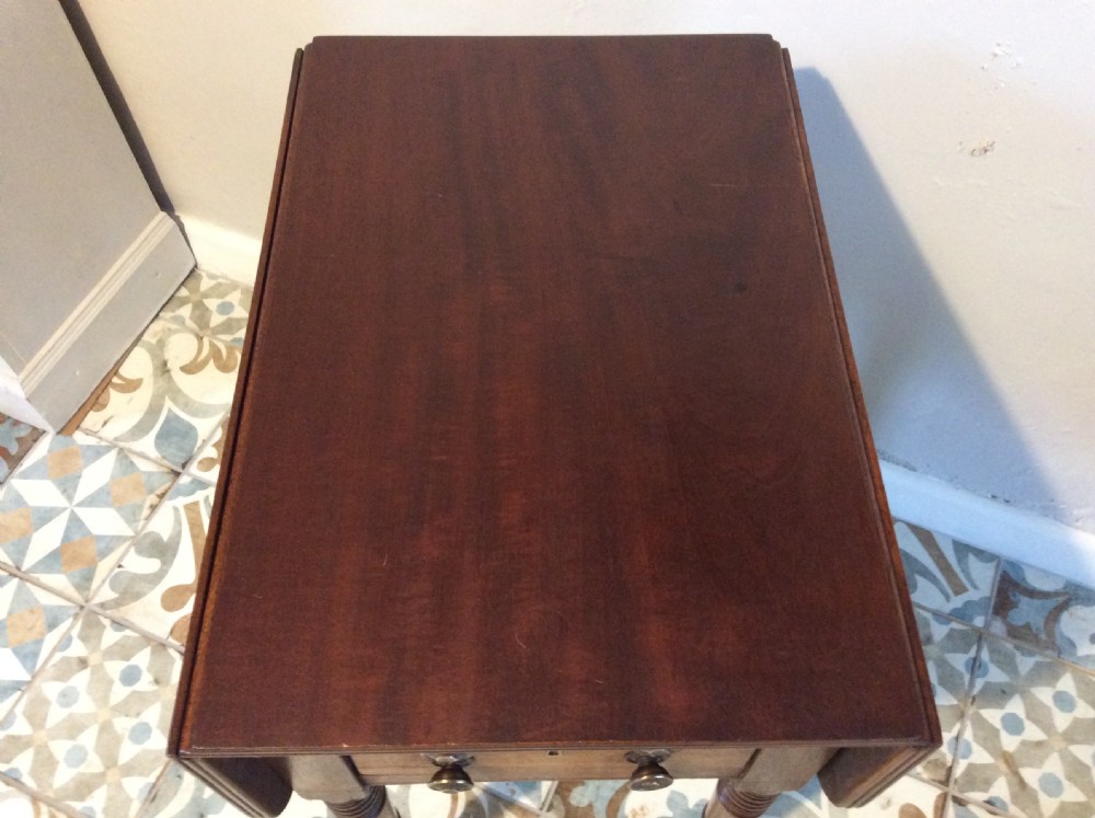A 19th-century mahogany work table featuring two drawers with circular knobs, double drop leaves, and slender turned legs on brass castors. View III