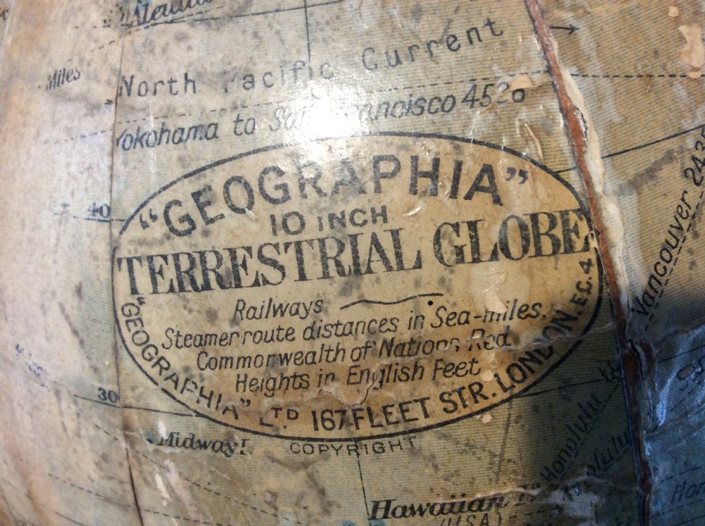 A printed paper terrestrial globe mounted on an ornate cast iron tripod base with a metal semi-meridian arm. View II