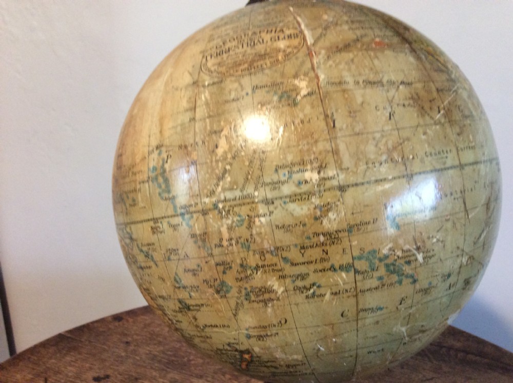 A printed paper terrestrial globe mounted on an ornate cast iron tripod base with a metal semi-meridian arm. View XI