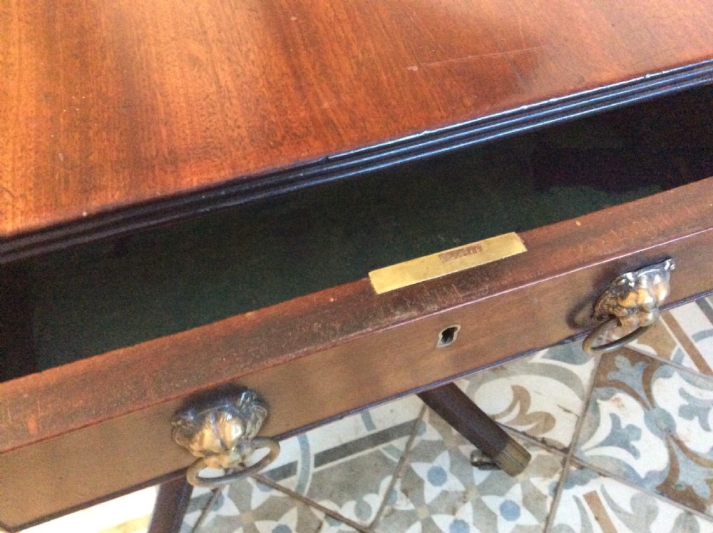 A Georgian mahogany drop-leaf hall table with two hinged side flaps, supported by a central pedestal and four curved splayed legs with brass castors. View XIV