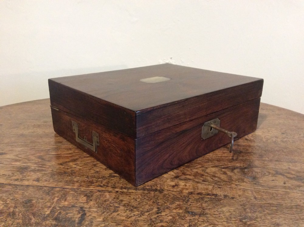 A closed 19th-century dark mahogany campaign writing slope with flush brass side handles and a brass escutcheon with key.