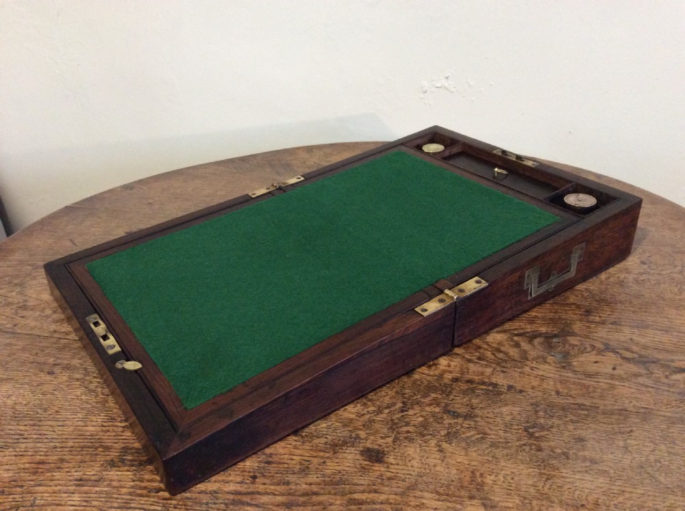 A closed 19th-century dark mahogany campaign writing slope with flush brass side handles and a brass escutcheon with key. View II