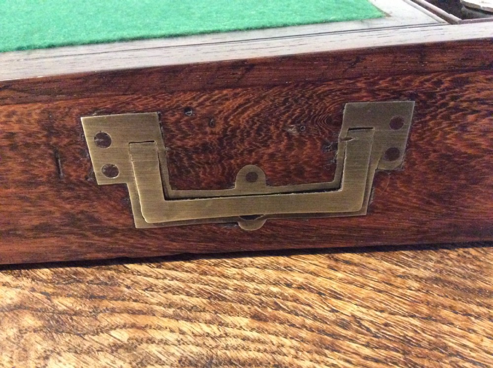 A closed 19th-century dark mahogany campaign writing slope with flush brass side handles and a brass escutcheon with key. View III