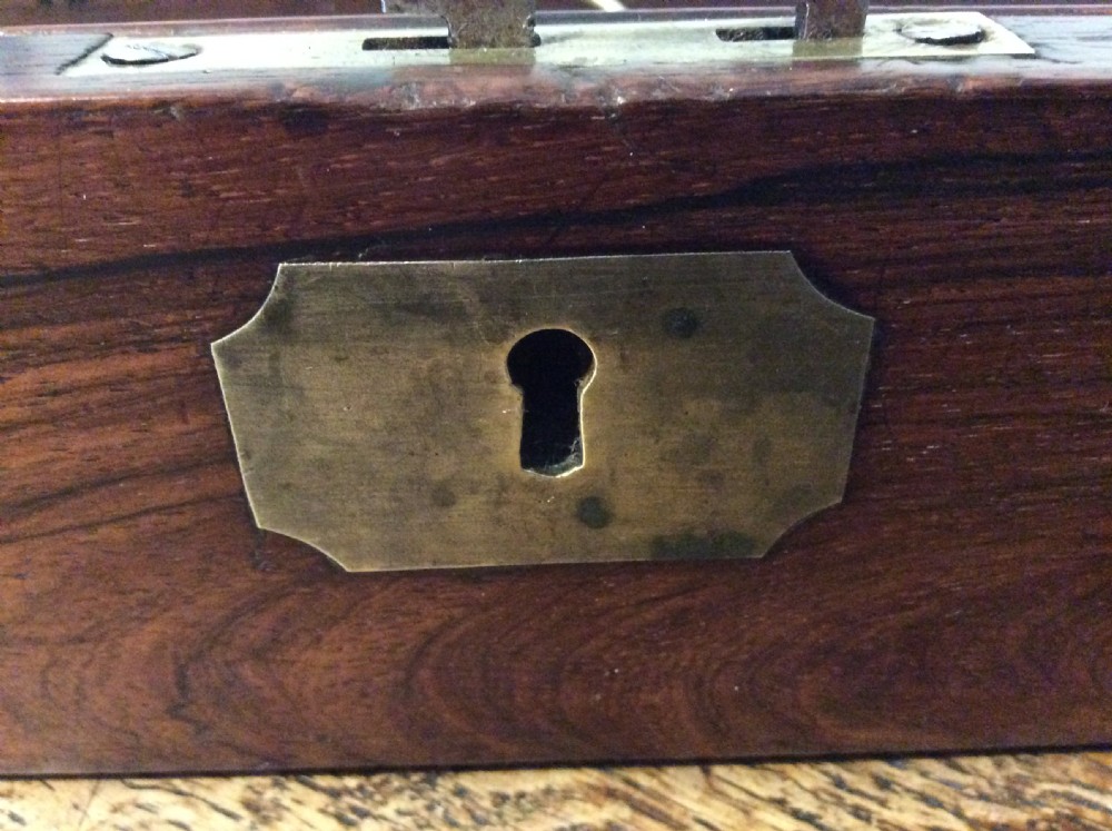 A closed 19th-century dark mahogany campaign writing slope with flush brass side handles and a brass escutcheon with key. View VII