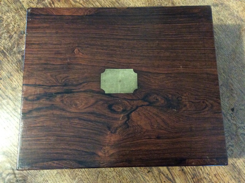 A closed 19th-century dark mahogany campaign writing slope with flush brass side handles and a brass escutcheon with key. View XI