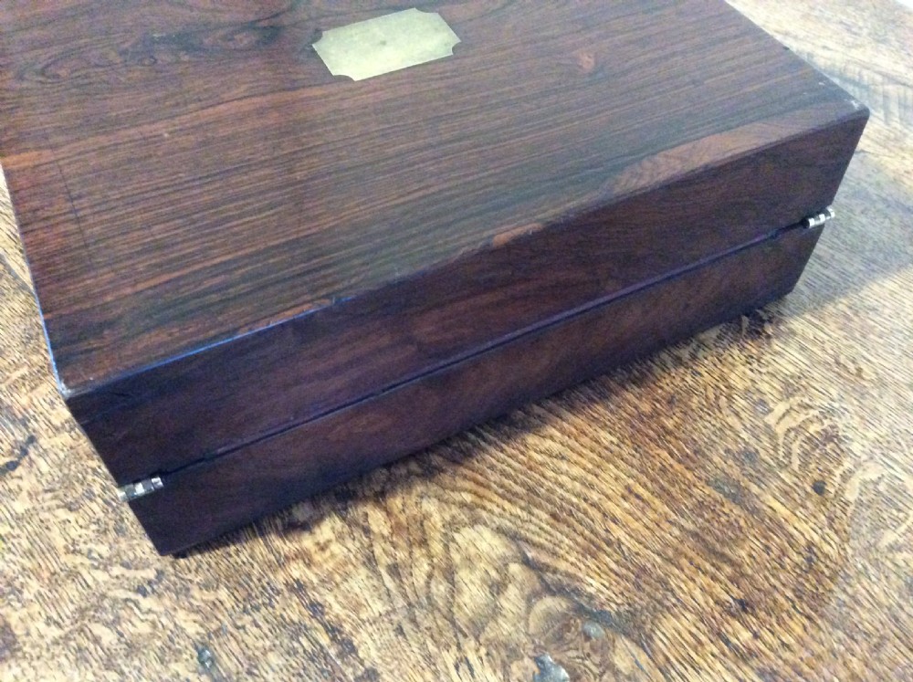 A closed 19th-century dark mahogany campaign writing slope with flush brass side handles and a brass escutcheon with key. View XV