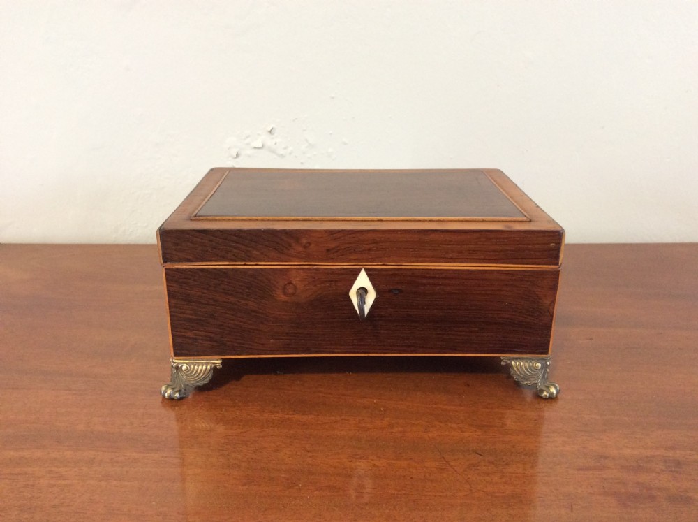 An open rectangular dark rosewood jewellery box featuring a diamond-shaped bone escutcheon, brass claw feet, and a dark lined interior. View II