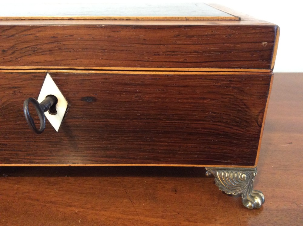 An open rectangular dark rosewood jewellery box featuring a diamond-shaped bone escutcheon, brass claw feet, and a dark lined interior. View III