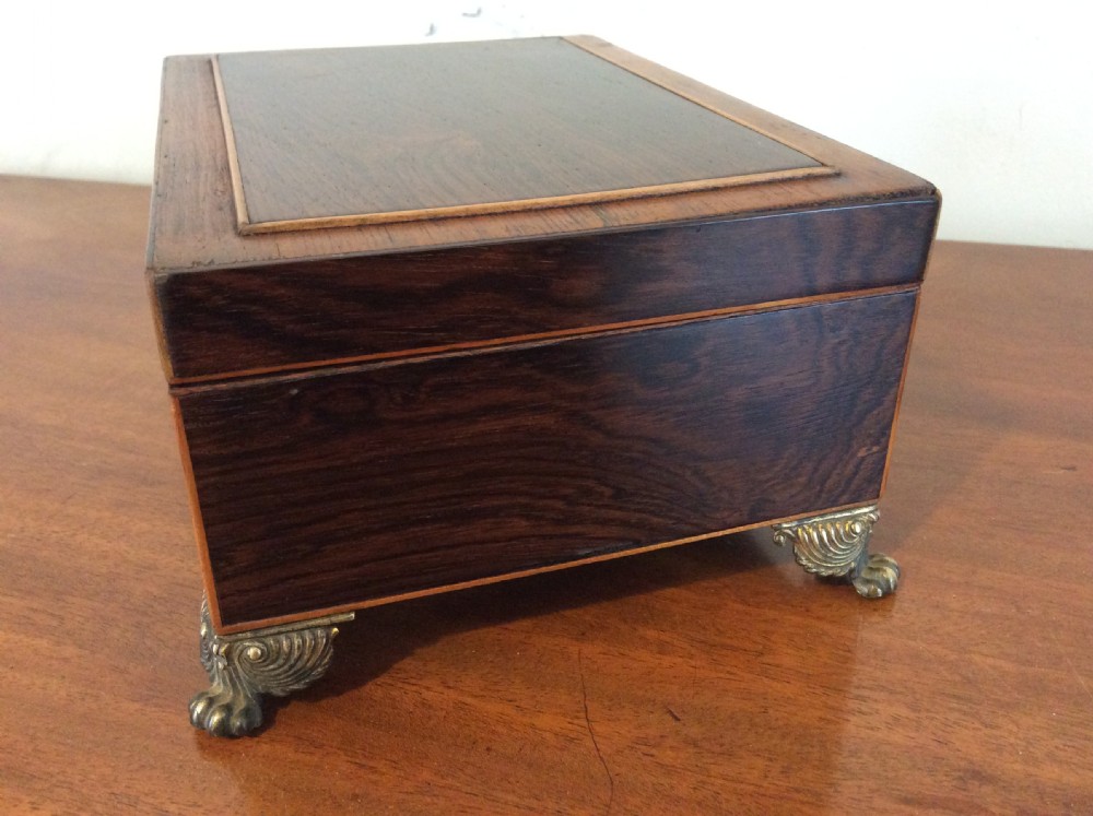 An open rectangular dark rosewood jewellery box featuring a diamond-shaped bone escutcheon, brass claw feet, and a dark lined interior. View VII