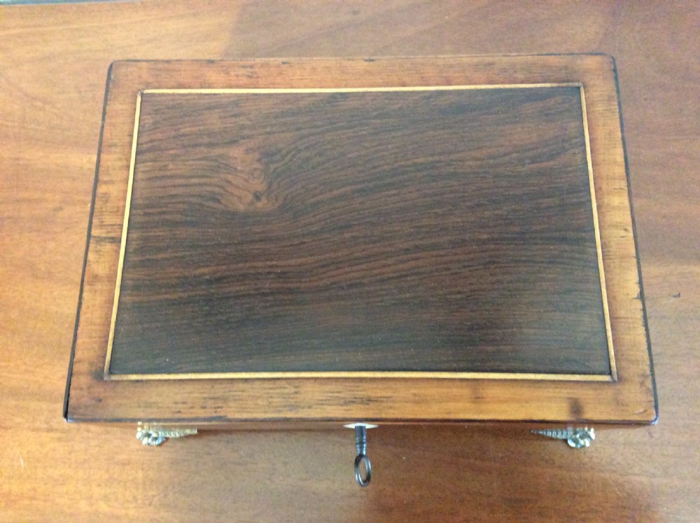 An open rectangular dark rosewood jewellery box featuring a diamond-shaped bone escutcheon, brass claw feet, and a dark lined interior. View VIII