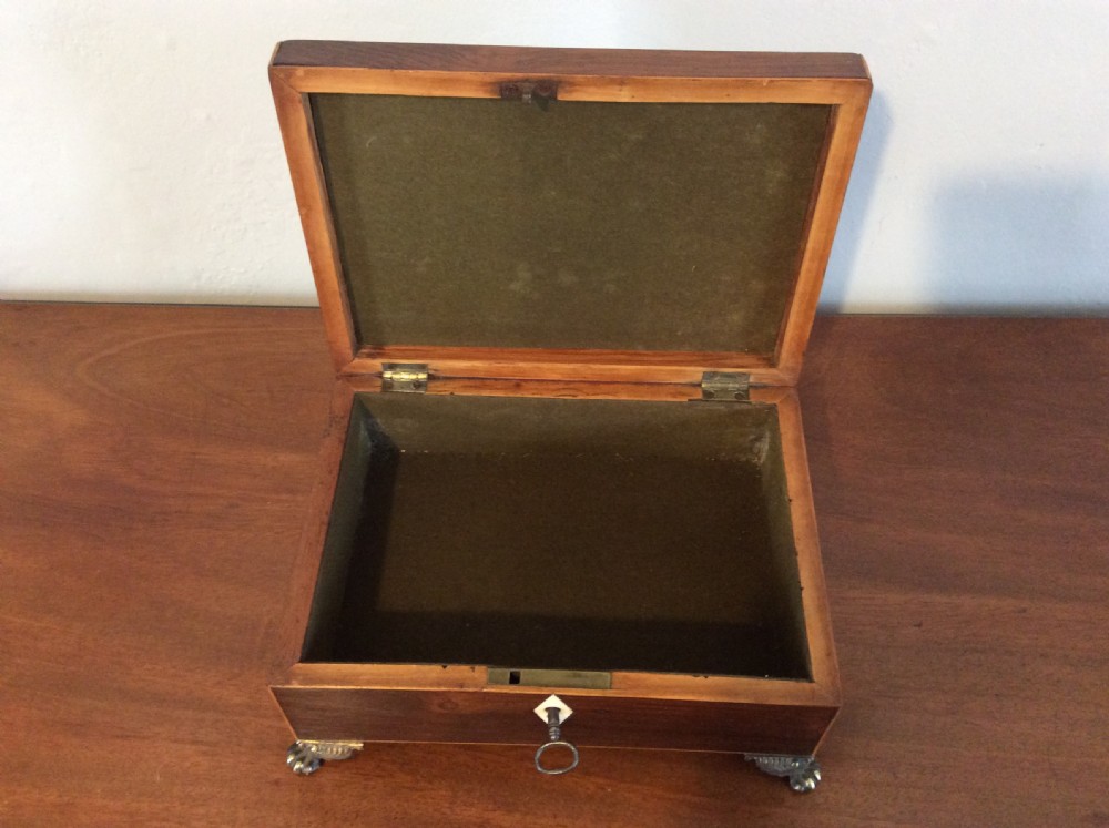 An open rectangular dark rosewood jewellery box featuring a diamond-shaped bone escutcheon, brass claw feet, and a dark lined interior. View IX