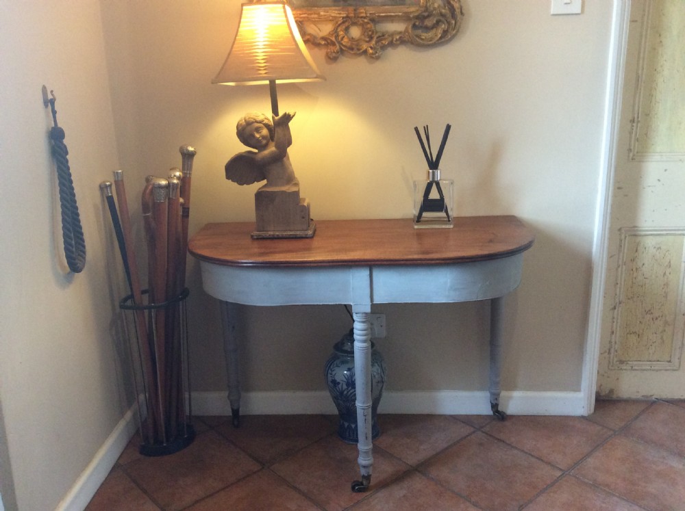 A nineteenth-century D-end console table featuring a polished dark wood top, light blue painted apron and turned legs set on brass castors. View III