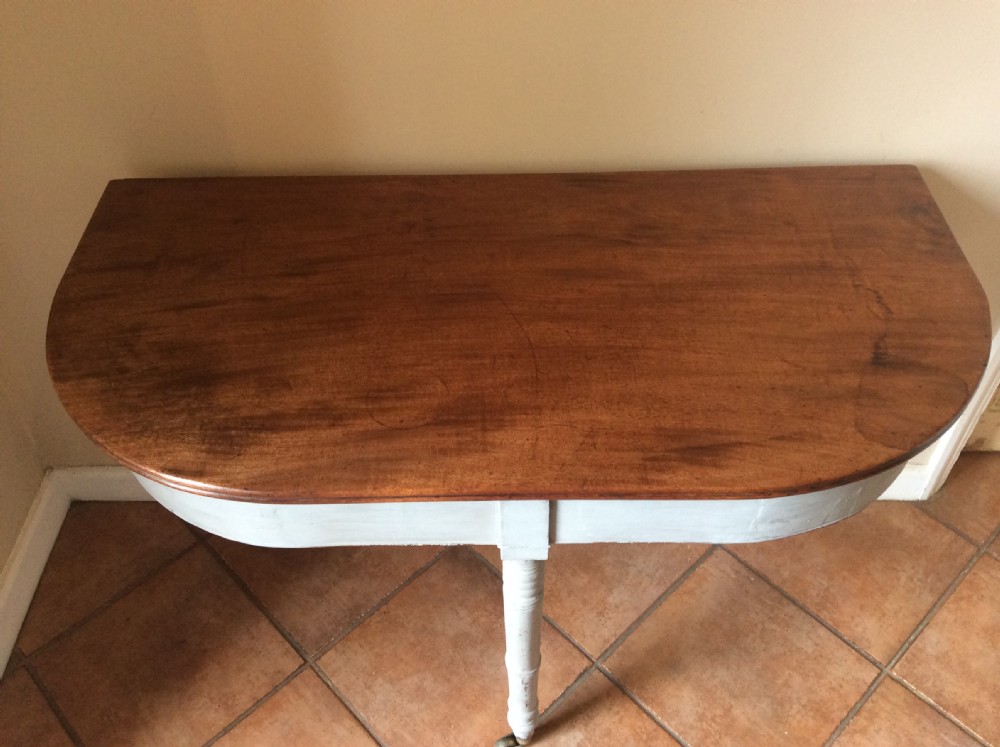 A nineteenth-century D-end console table featuring a polished dark wood top, light blue painted apron and turned legs set on brass castors. View V