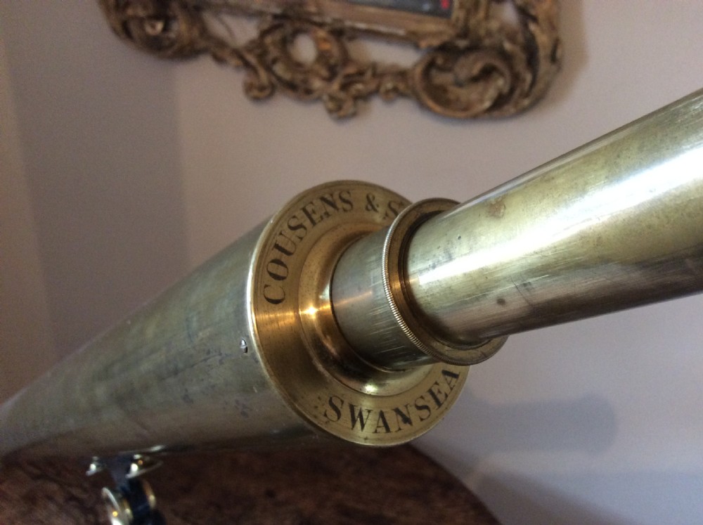 A nineteenth-century brass terrestrial library telescope supported by a dark tripod stand. View II