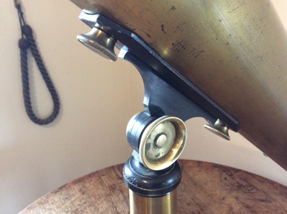 A nineteenth-century brass terrestrial library telescope supported by a dark tripod stand. View V
