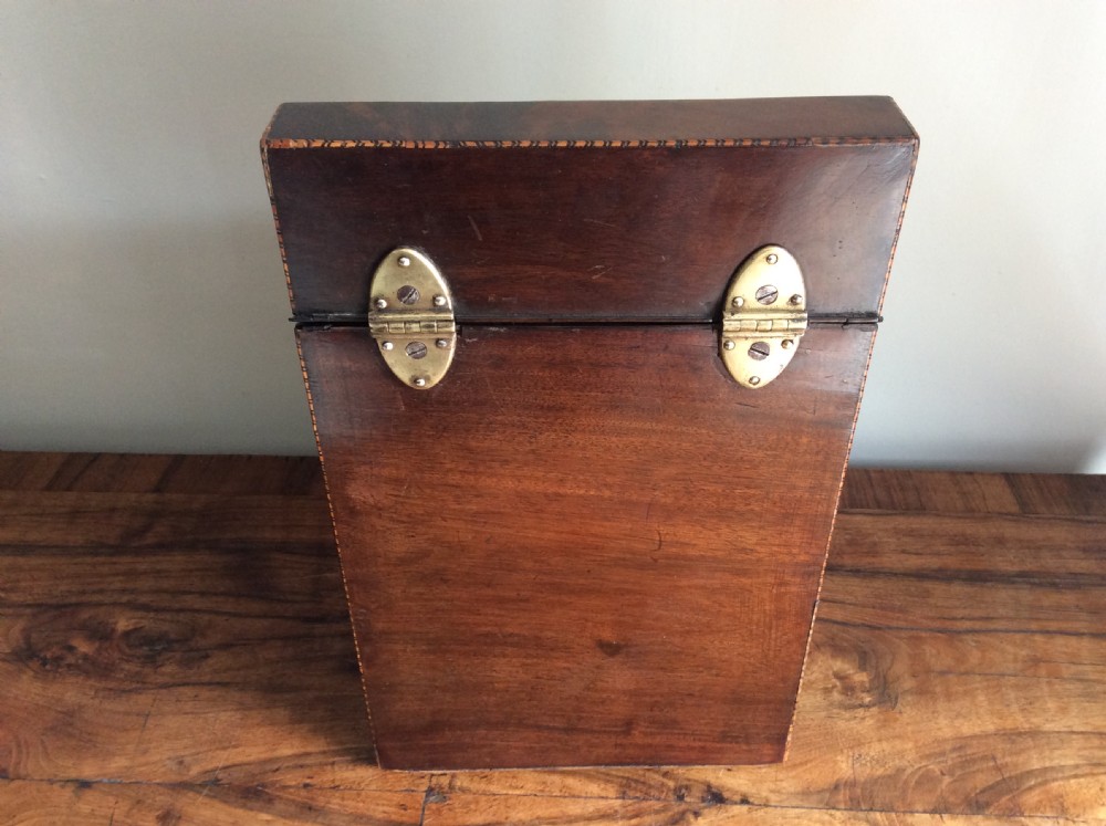 A Georgian mahogany knife box featuring a sloped hinged lid, serpentine front, boxwood stringing, and a metal keyhole escutcheon. View VIII