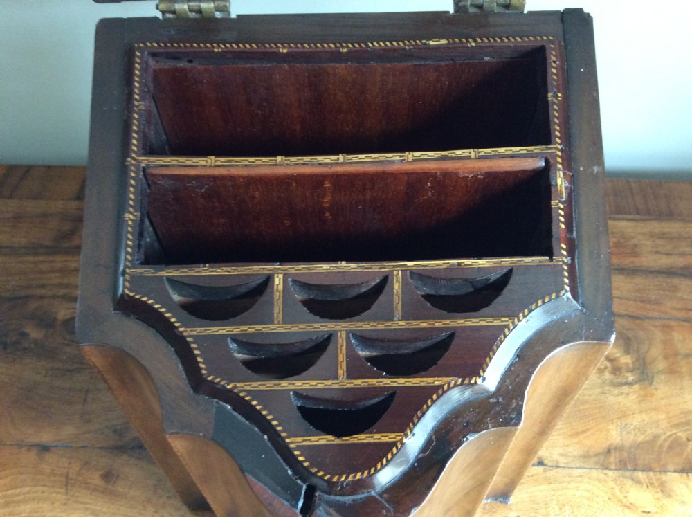 A Georgian mahogany knife box featuring a sloped hinged lid, serpentine front, boxwood stringing, and a metal keyhole escutcheon. View X