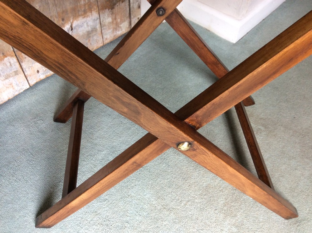 A nineteenth-century mahogany butlers tray featuring raised gallery sides with cut-out handles, resting on a folding X-frame wooden stand. View VI