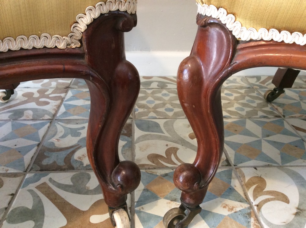 A near pair of Victorian button-backed tub armchairs upholstered in yellow fabric with carved mahogany cabriole legs on castors. View XI