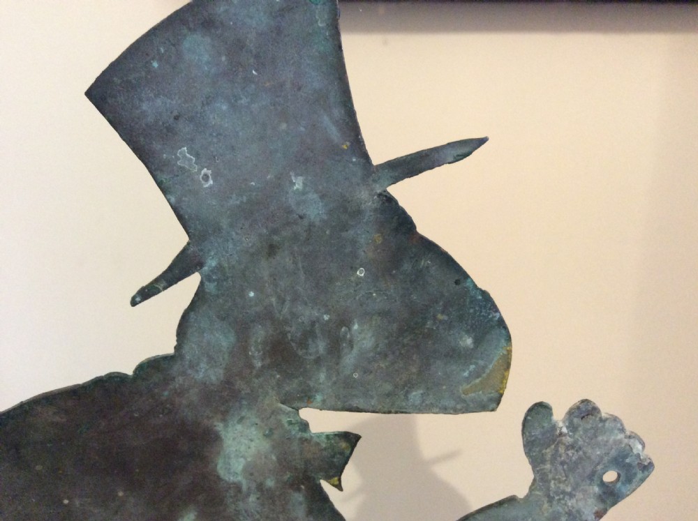 An early 20th-century copper weather vane featuring running figures with a natural verdigris patina, mounted on a stone block stand. View XIII