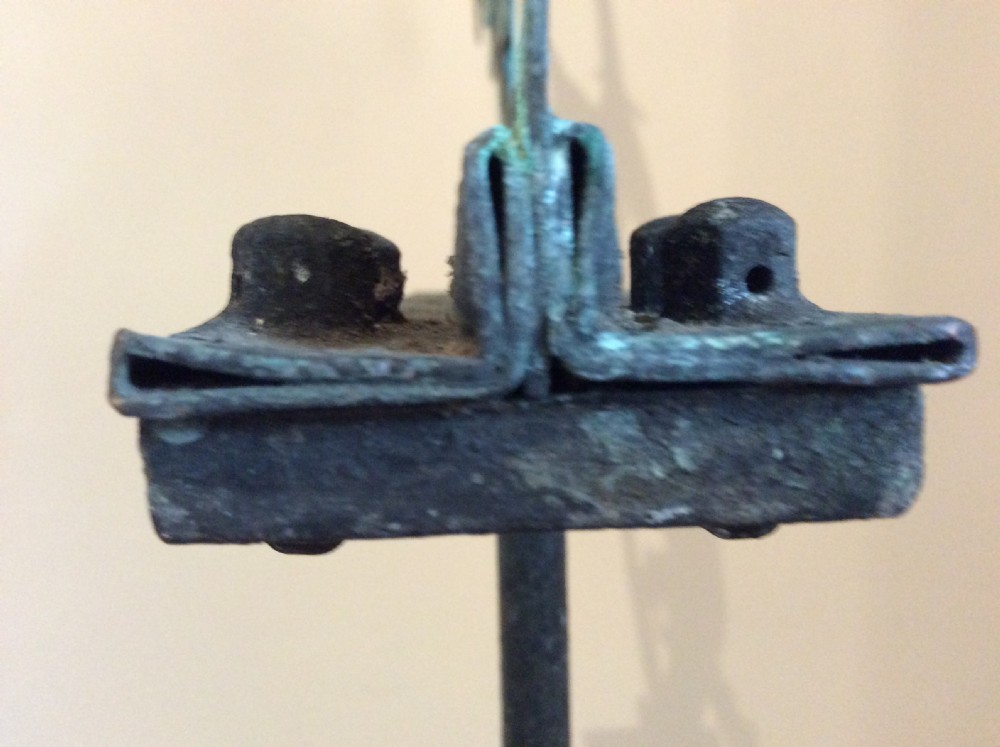 An early 20th-century copper weather vane featuring running figures with a natural verdigris patina, mounted on a stone block stand. View XVIII