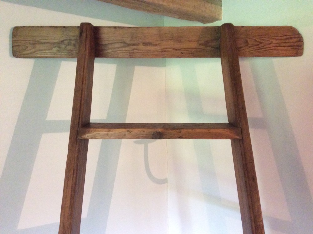 A tall Victorian pine shop ladder featuring straight wooden stiles, flat horizontal rungs, and a top mounting bar. View II