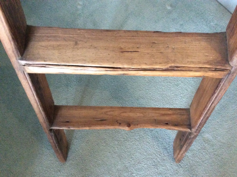 A tall Victorian pine shop ladder featuring straight wooden stiles, flat horizontal rungs, and a top mounting bar. View III