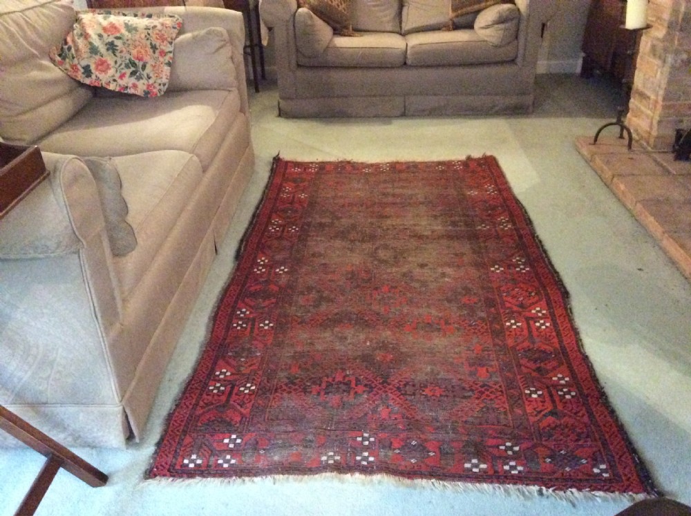 A well worn antique Afgan Baluch rug