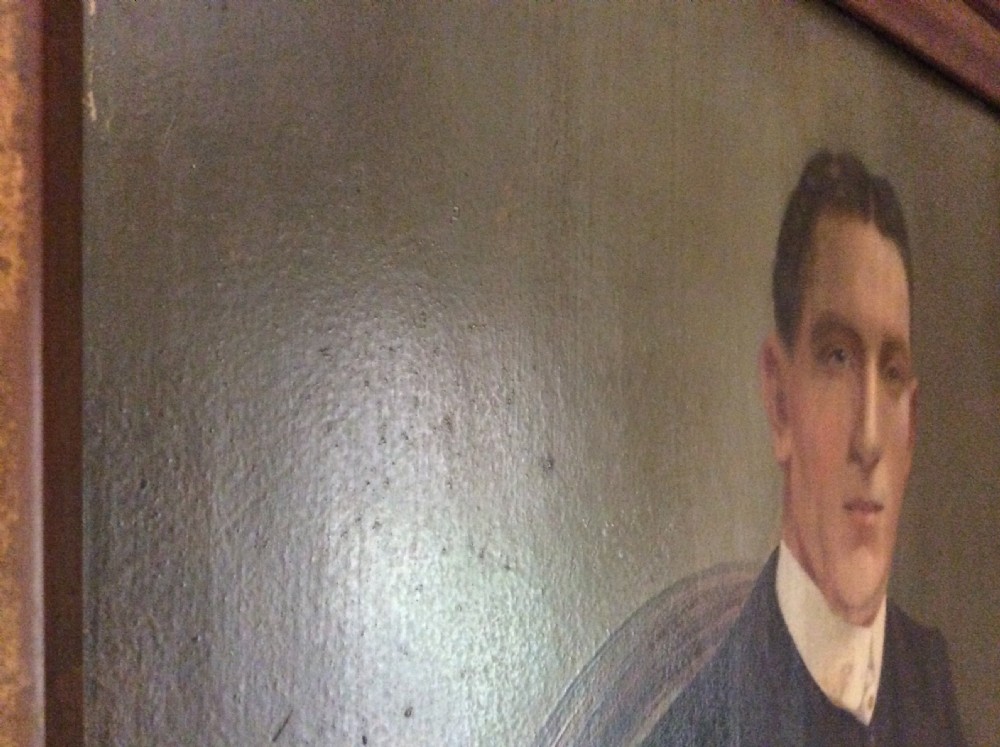An antique oil painting depicting a seated gentleman in formal dark attire set within a heavily carved gold leaf frame. View VII