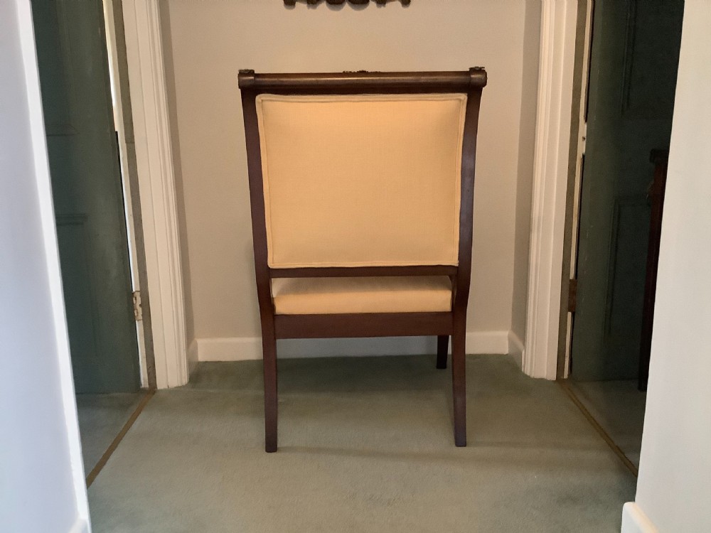 A 19th-century French Empire mahogany open armchair featuring light gold-coloured fabric upholstery and ornate brass leaf mounts. View V