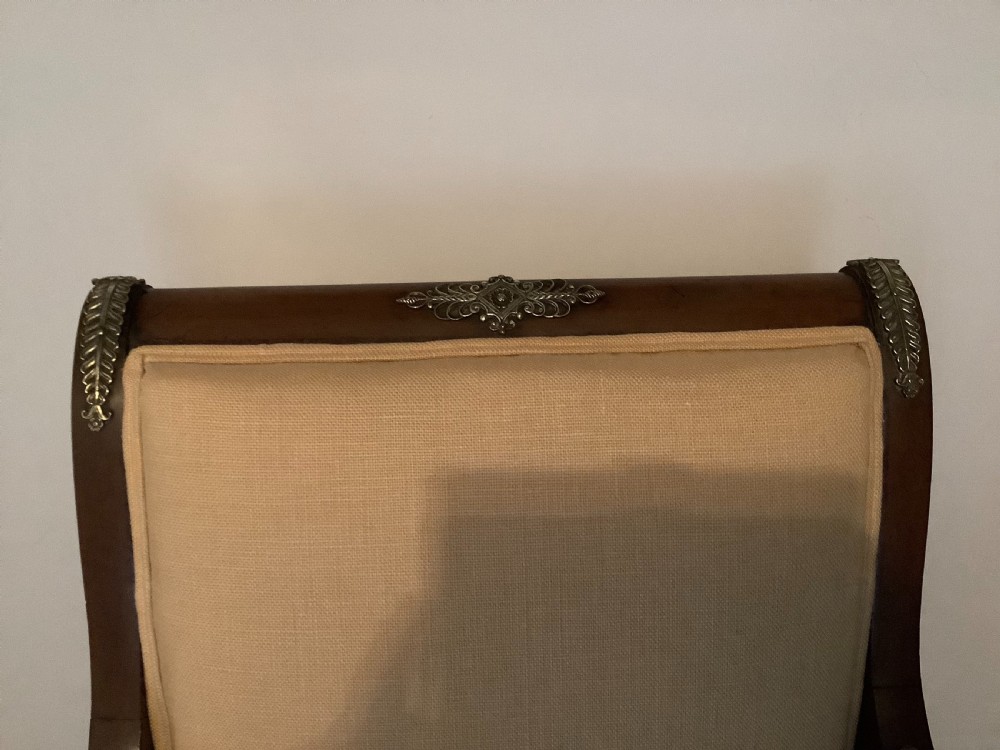 A 19th-century French Empire mahogany open armchair featuring light gold-coloured fabric upholstery and ornate brass leaf mounts. View VIII