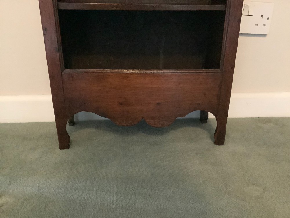 A small dark wood open French dwarf bookcase featuring three shelf tiers, a top moulded cornice, and a scalloped base apron. View V