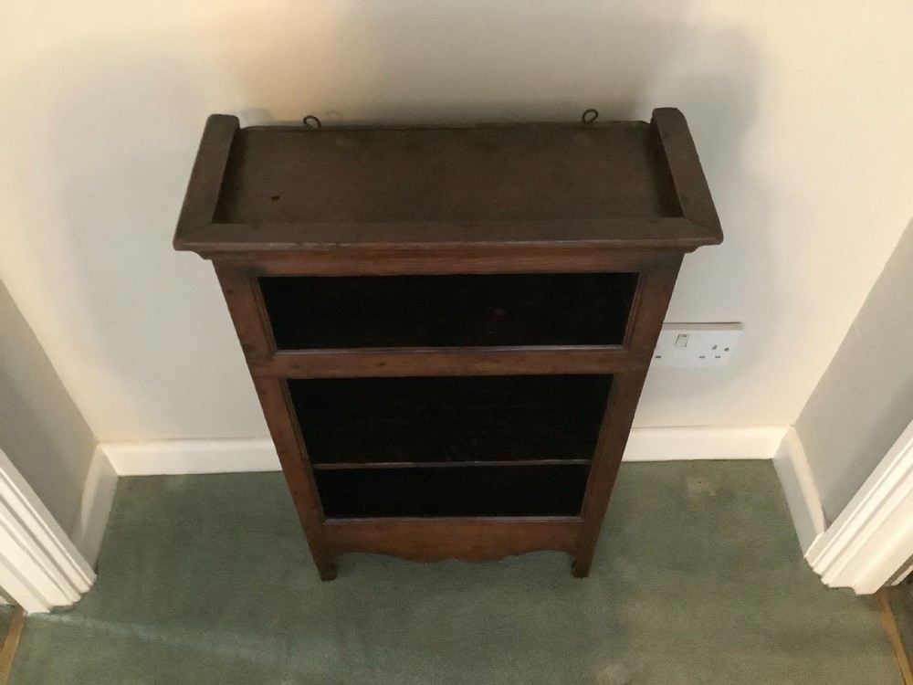A small dark wood open French dwarf bookcase featuring three shelf tiers, a top moulded cornice, and a scalloped base apron. View VII