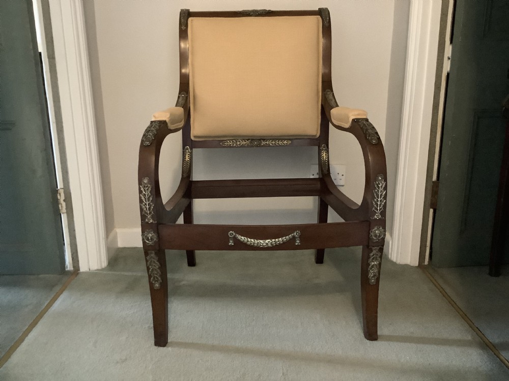 A 19th-century French Empire mahogany open armchair featuring light gold-coloured fabric upholstery and ornate brass leaf mounts. View XI