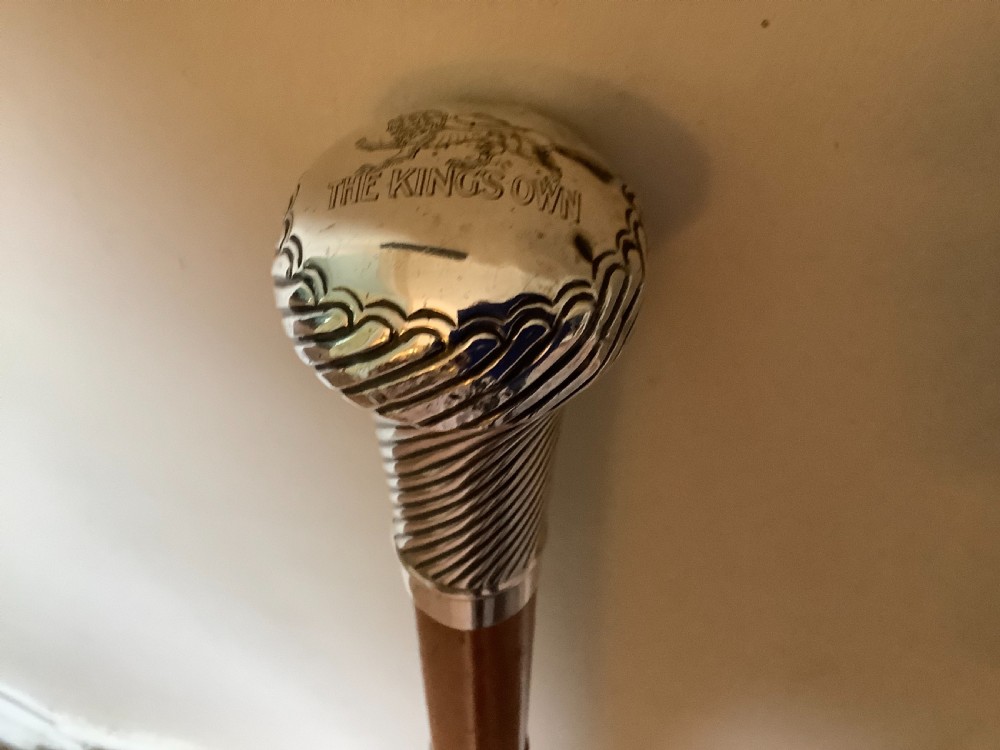 A wooden walking cane featuring a swirl-fluted hallmarked silver pommel top and silver collar. View II