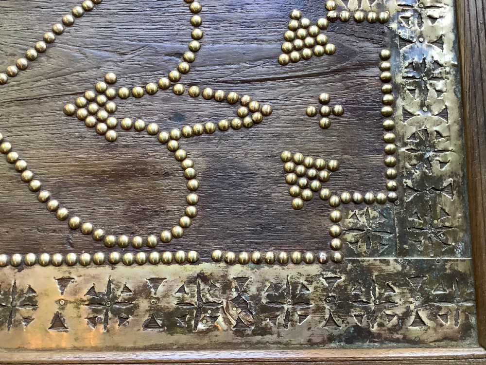 A nineteenth-century wooden Zanzibar storage chest decorated with intricate brass studs, pierced metal plates, three lower drawers, and brass handles. View XI