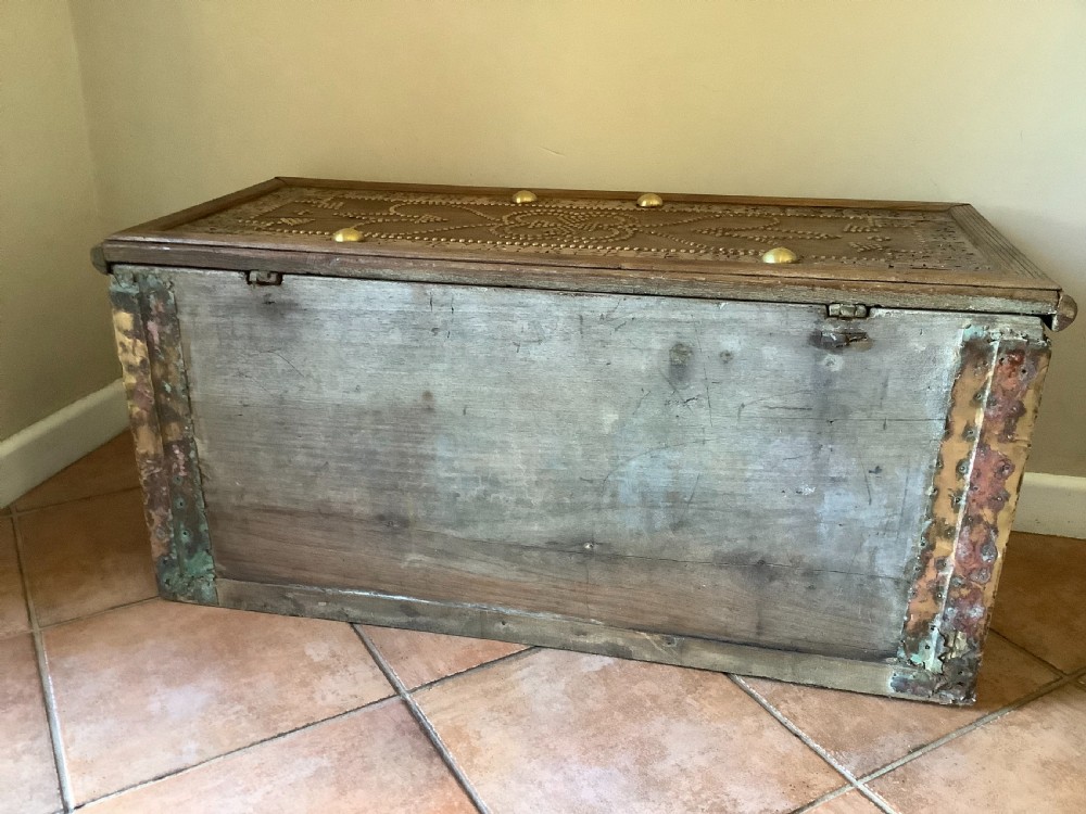 A nineteenth-century wooden Zanzibar storage chest decorated with intricate brass studs, pierced metal plates, three lower drawers, and brass handles. View XIV