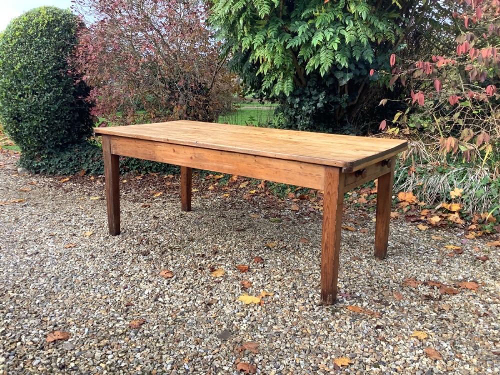 A Victorian pine farmhouse dining table with a rectangular timber top and straight tapered legs.
