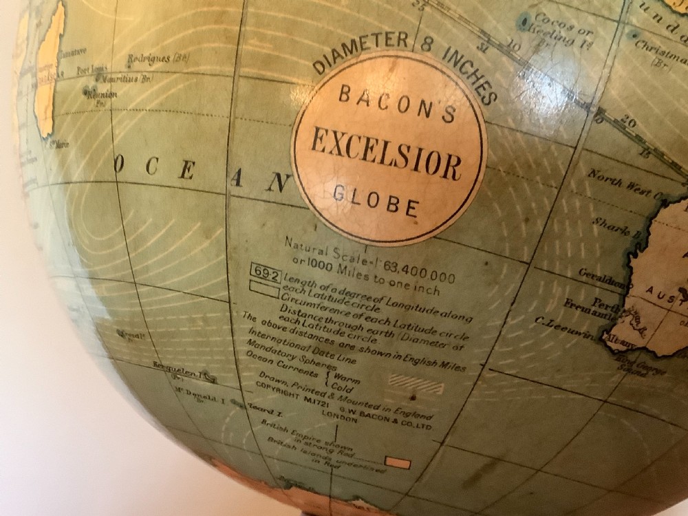 An antique terrestrial desk globe featuring printed paper gores, a brass semi-meridian arc, and a dark turned wooden base. View II