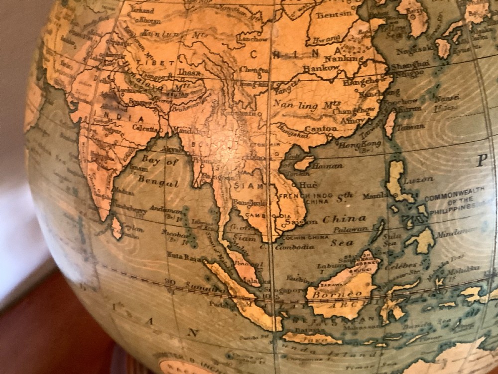 An antique terrestrial desk globe featuring printed paper gores, a brass semi-meridian arc, and a dark turned wooden base. View IV