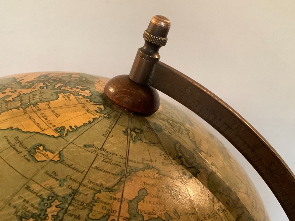 An antique terrestrial desk globe featuring printed paper gores, a brass semi-meridian arc, and a dark turned wooden base. View VII