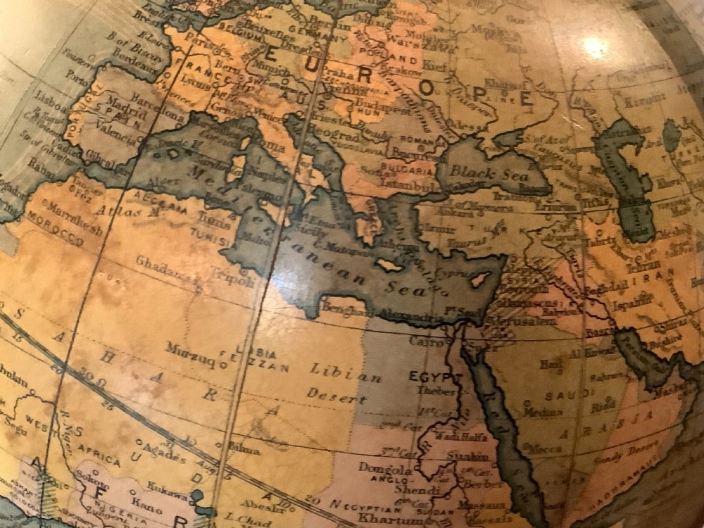 An antique terrestrial desk globe featuring printed paper gores, a brass semi-meridian arc, and a dark turned wooden base. View VIII