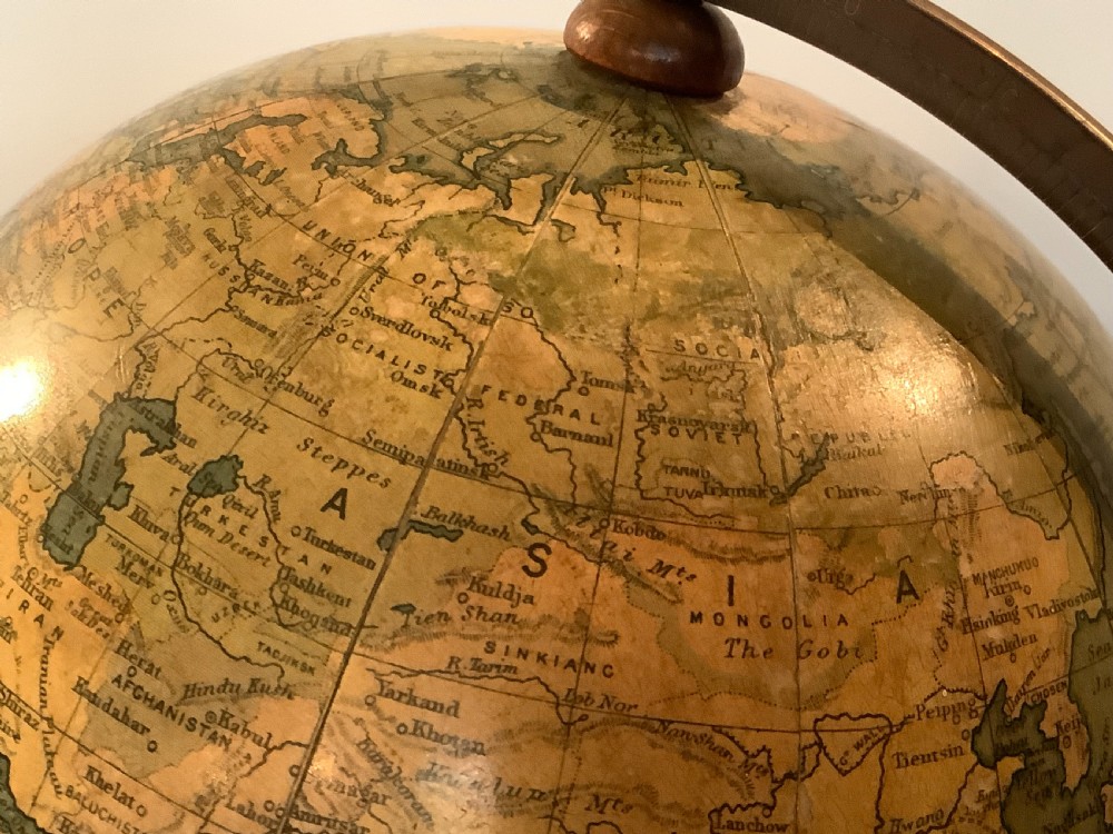 An antique terrestrial desk globe featuring printed paper gores, a brass semi-meridian arc, and a dark turned wooden base. View IX