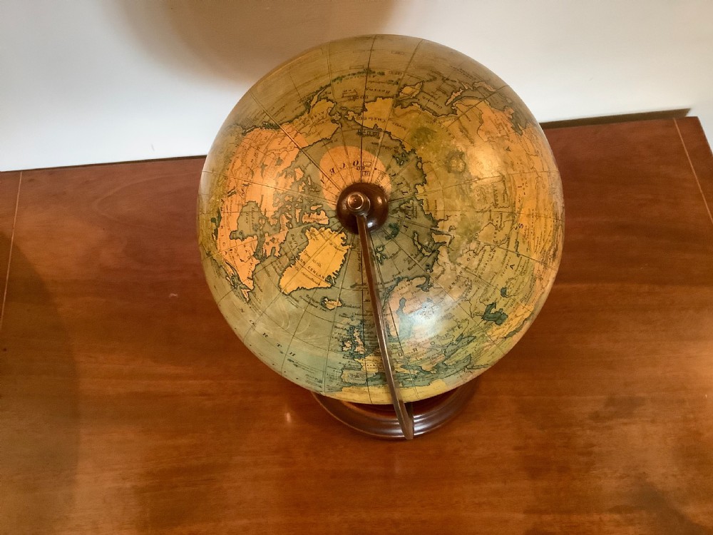 An antique terrestrial desk globe featuring printed paper gores, a brass semi-meridian arc, and a dark turned wooden base. View XIII