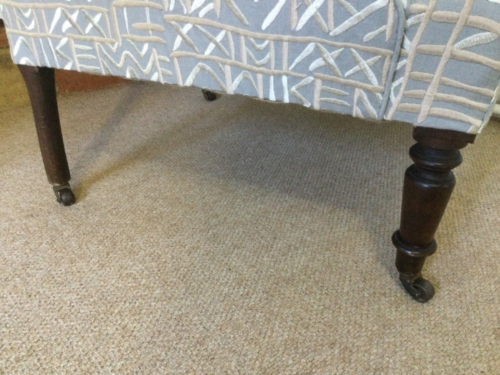 A 19th-century French armchair re-upholstered in a grey and white geometric patterned fabric with dark turned wood front legs on castors. View III