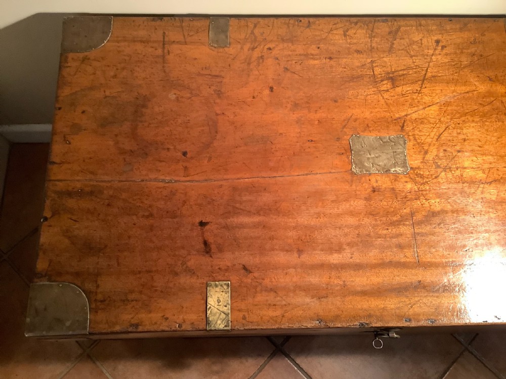 A rectangular warm brown camphor wood campaign trunk featuring corner brass brackets, flush brass straps, and a central brass ring handle. View XIII