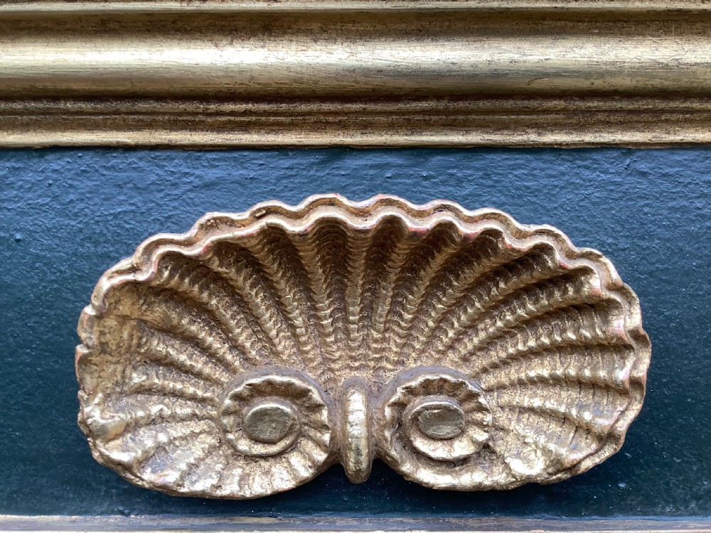 A 19th-century giltwood triple plate overmantel mirror featuring spiral-twist side columns, a dark painted frieze with gold rosettes, and a central carved shell motif. View II