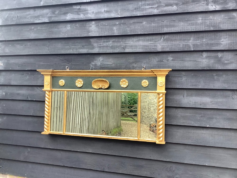 A 19th-century giltwood triple plate overmantel mirror featuring spiral-twist side columns, a dark painted frieze with gold rosettes, and a central carved shell motif. View III